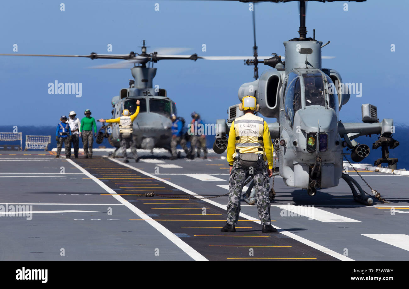Ein United States Marine Corps (USMC) AH-1W SuperCobra Hubschrauber (vorne) und UH-1Y Venom medium Utility Helicopter (hinten) Rest auf dem Flugdeck der HMAS Canberra während der 'Freeplay' Phase der Übung der Pacific Rim (Rimpac) 2016. Der Pacific Rim (Rimpac) ist ein US Pacific Fleet-gehostete Biennale multinationale maritime Übung zu fördern und die internationale Zusammenarbeit auf dem Gebiet der Sicherheit der Ozeane der Welt unterstützen. (Australian Defence Force Foto von POIS Yuri Ramsey) Stockfoto