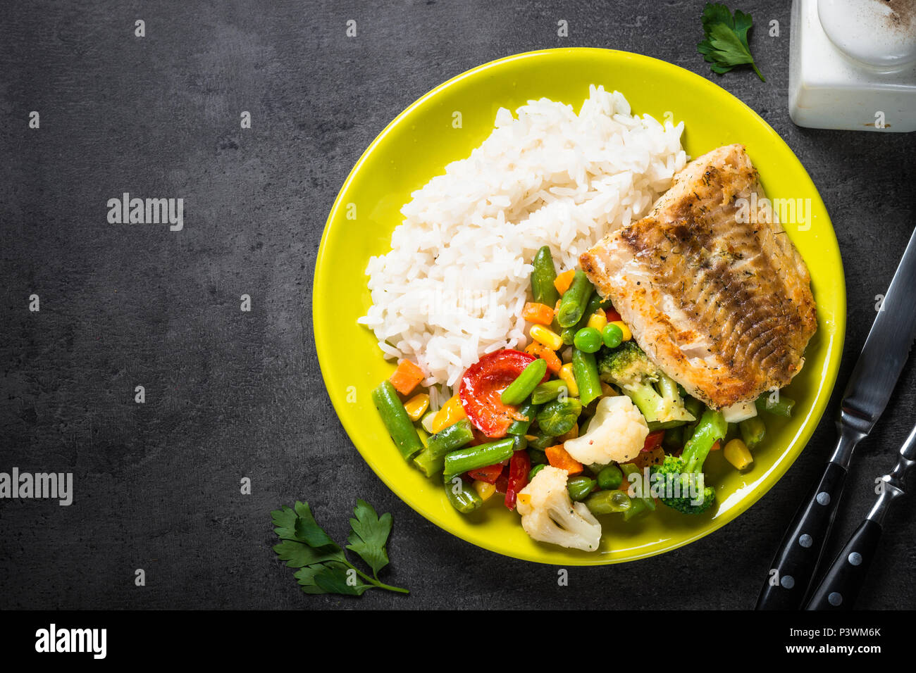 Fisch, Aufstieg und Gemüse in grüne Platte auf schwarzem Hintergrund. Gesundes Essen Menü. Ansicht von oben. Stockfoto