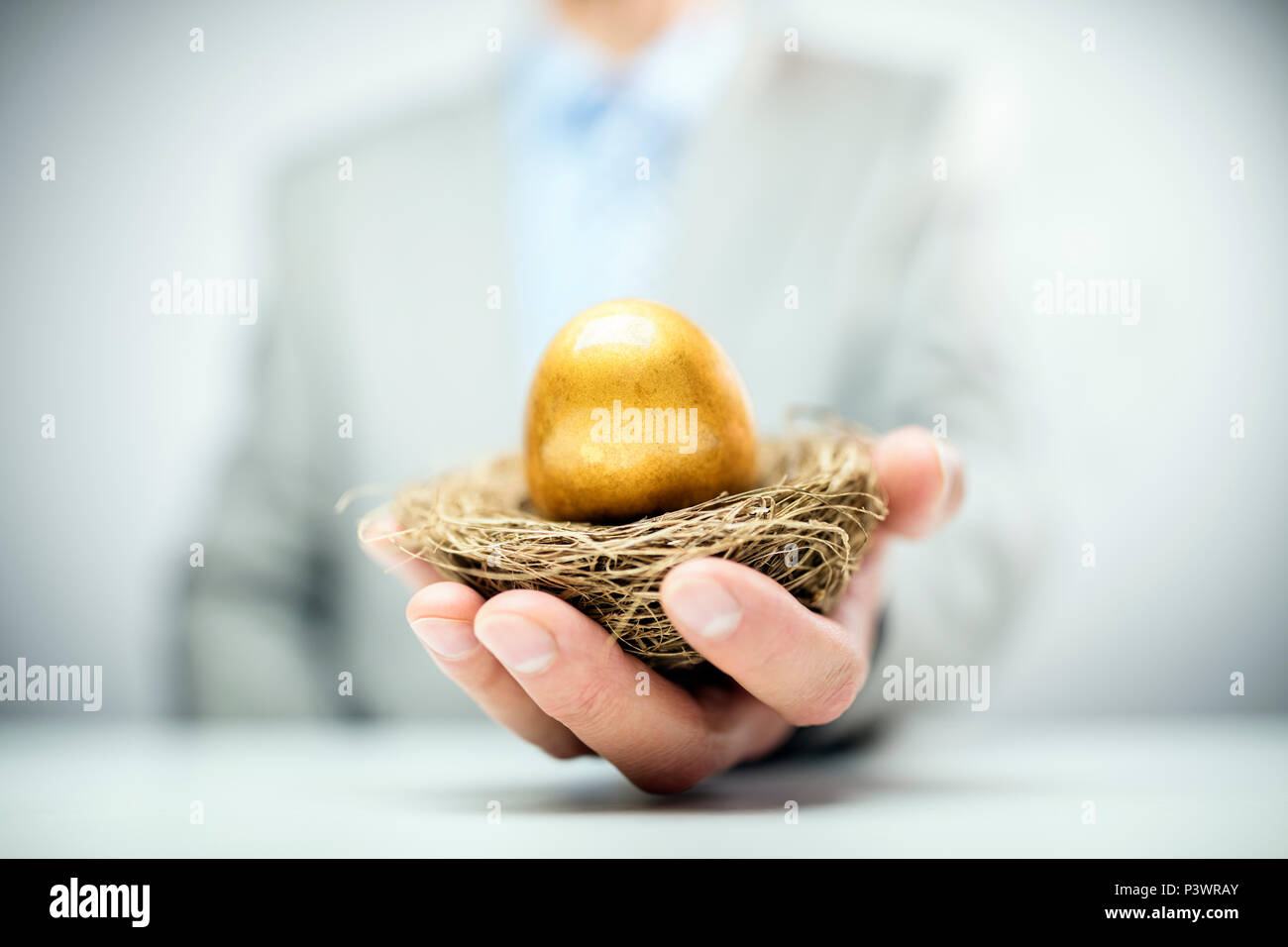 Altersvorsorge Golden Nest Ei in einer businessmans Hand Stockfoto