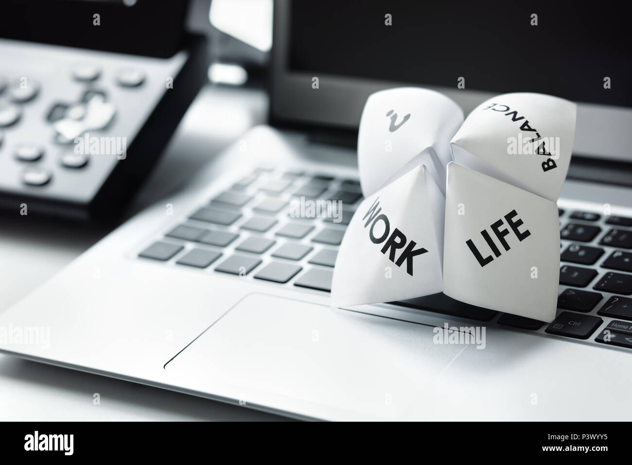 Origami Fortune Teller auf Laptop im Büro Konzept für Work Life Balance Entscheidungen Stockfoto