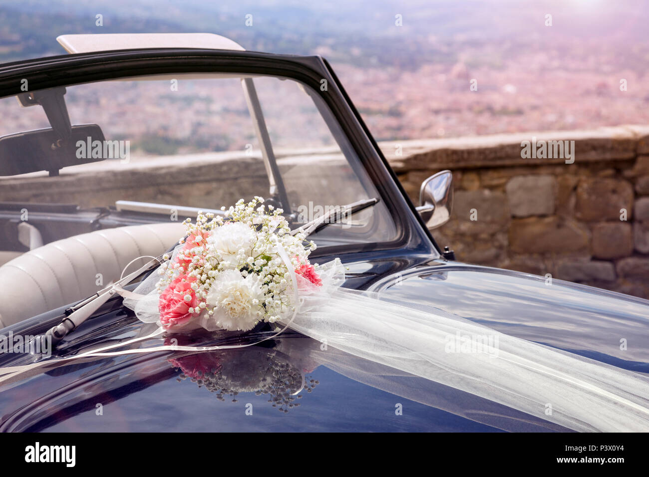 Vintage Hochzeit Auto mit Blumenstrauß und Band auf der Motorhaube Stockfoto