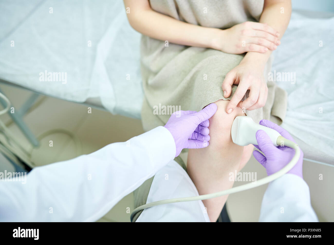 Die ärztliche Untersuchung der Knie im Krankenhaus mit Apparat Stockfoto
