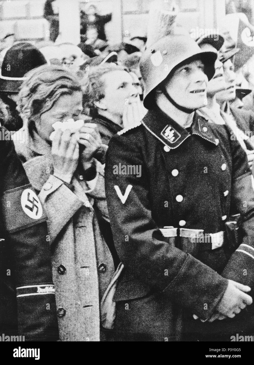 ADMIRADORES DE HITLER - SOLDADO DE LA SS Y PUBLICO ESCUCHANDO DISCURSO. Stockfoto