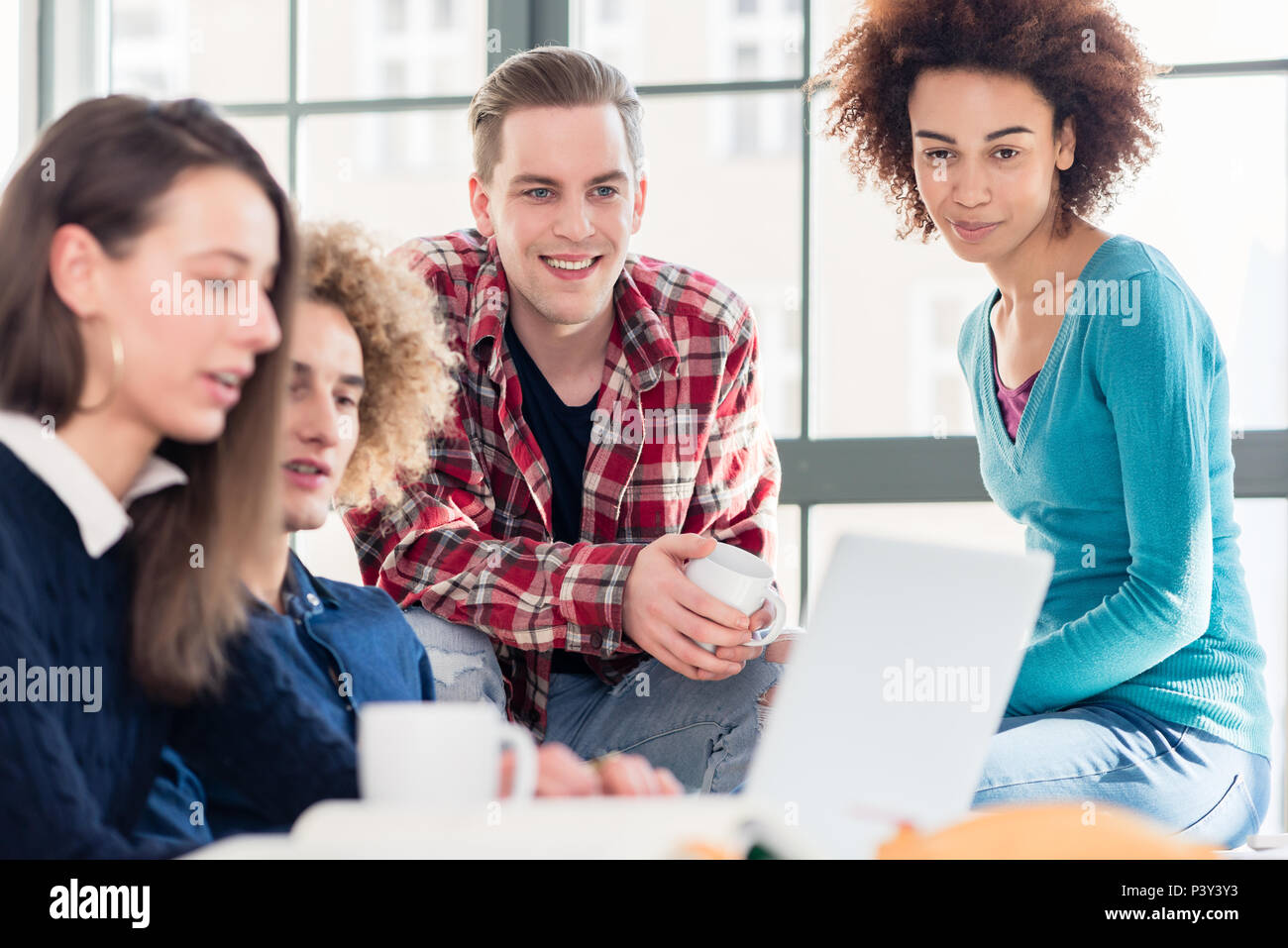 Die Studierenden gemeinsam ein lustiges online Video auf einem Laptop in der Pause Stockfoto