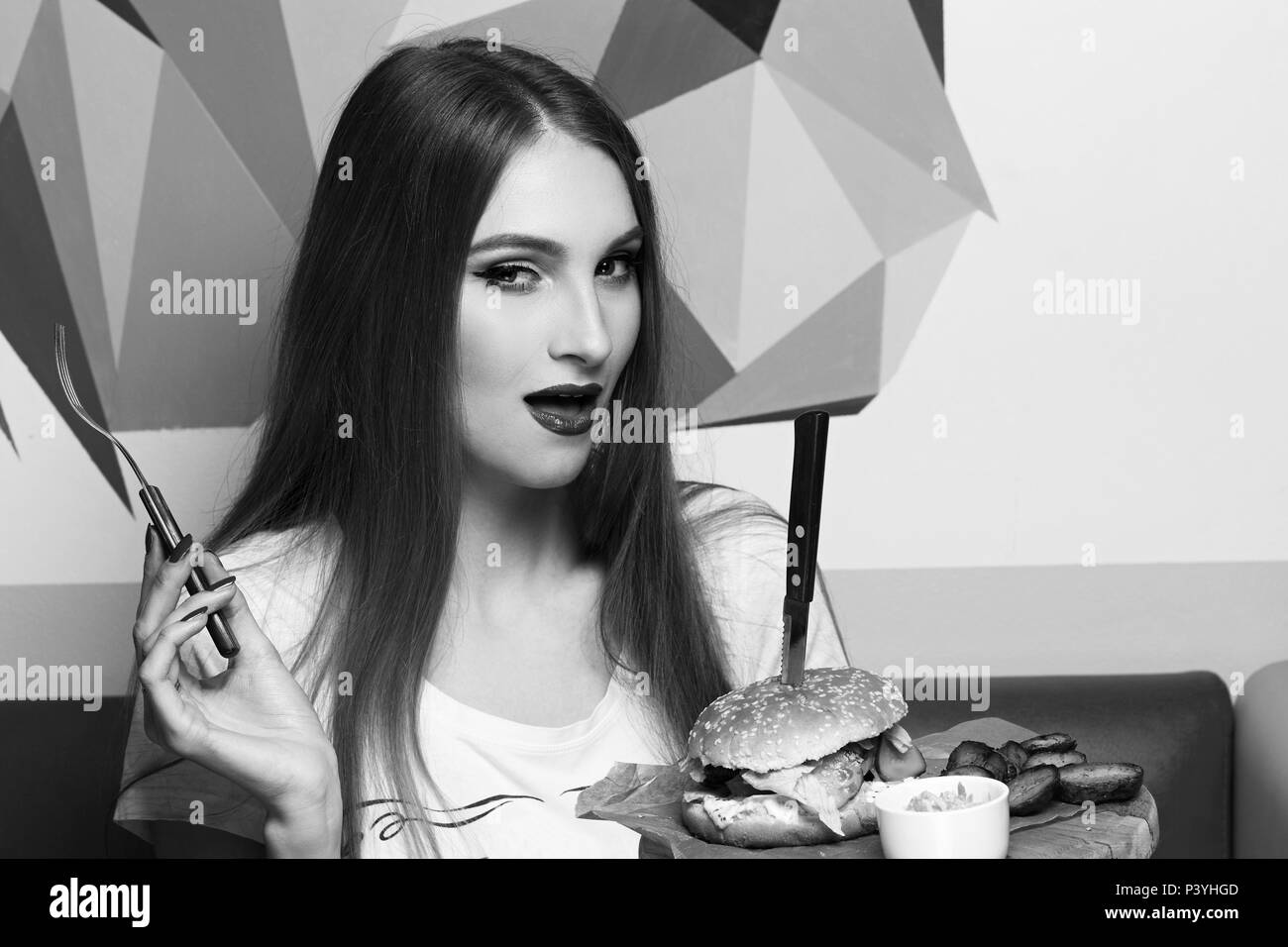 Lachende Frau Burger essen Stockfoto