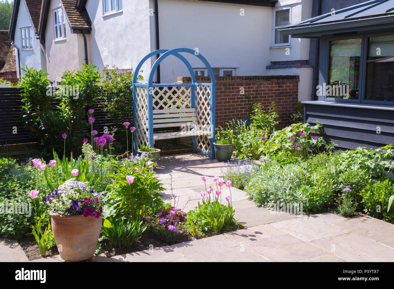 Überblick über blau Laube Sitzecke, Küche und Garten Terrasse grenzen mit Tulipa 'Pink Diamond', Artemisia ludoviciana 'Valerie Finn Stockfoto