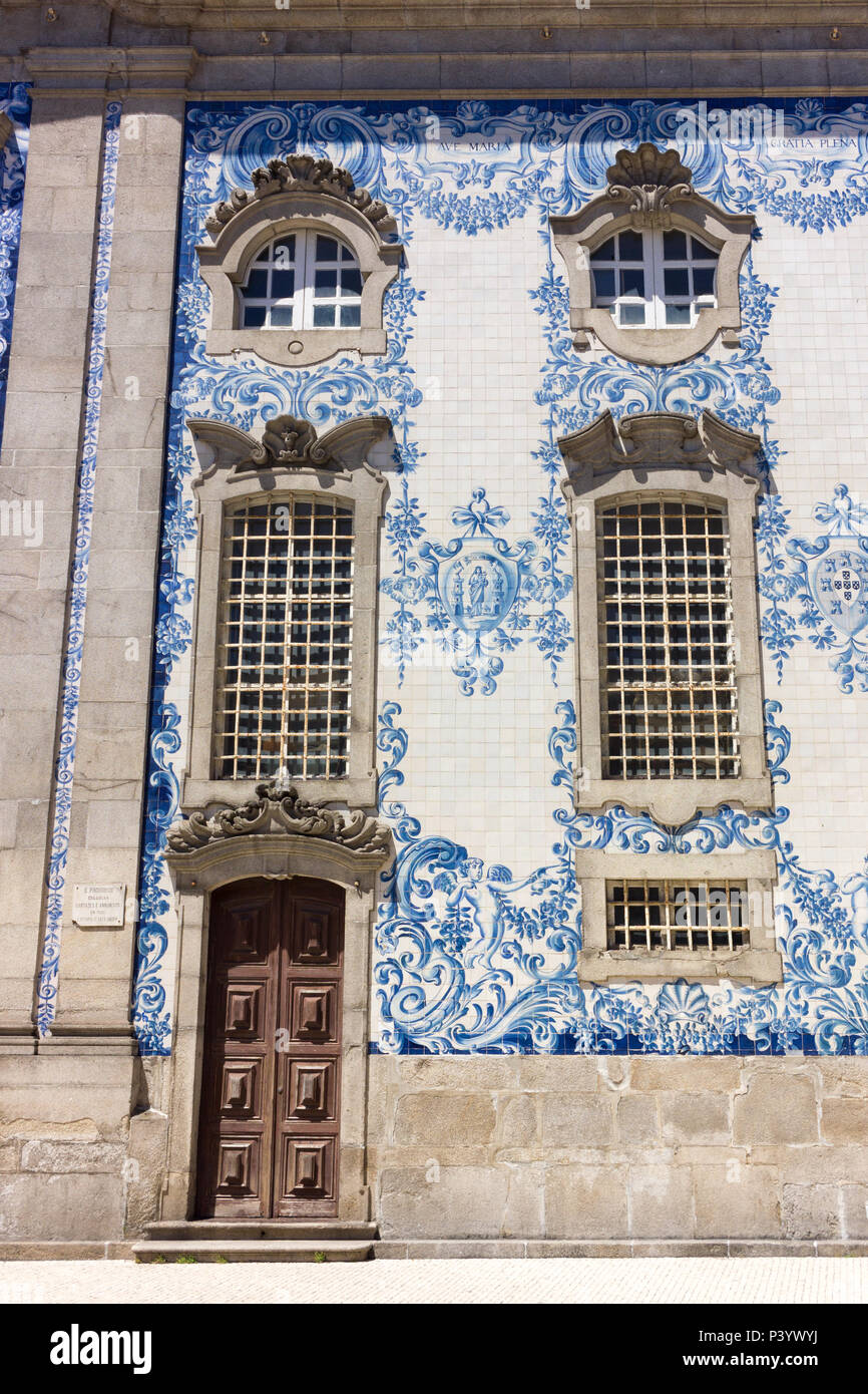 Seitenwand von Carmo Kirche mit ihrem berühmten blauen und weißen Fliesen in Porto, Portugal. Tür und Fenster. Azulejo. Igreja do Carmo. Stockfoto