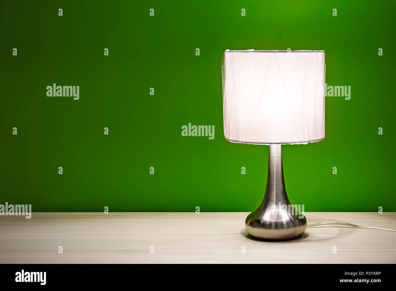 Nachttischlampe auf dem Tisch für den Innenbereich isoliert. Nacht Lampe  mit runden Schatten stehend auf einem Holztisch, auf dem Hintergrund der  grüne Wände bur zu lesen Stockfotografie - Alamy