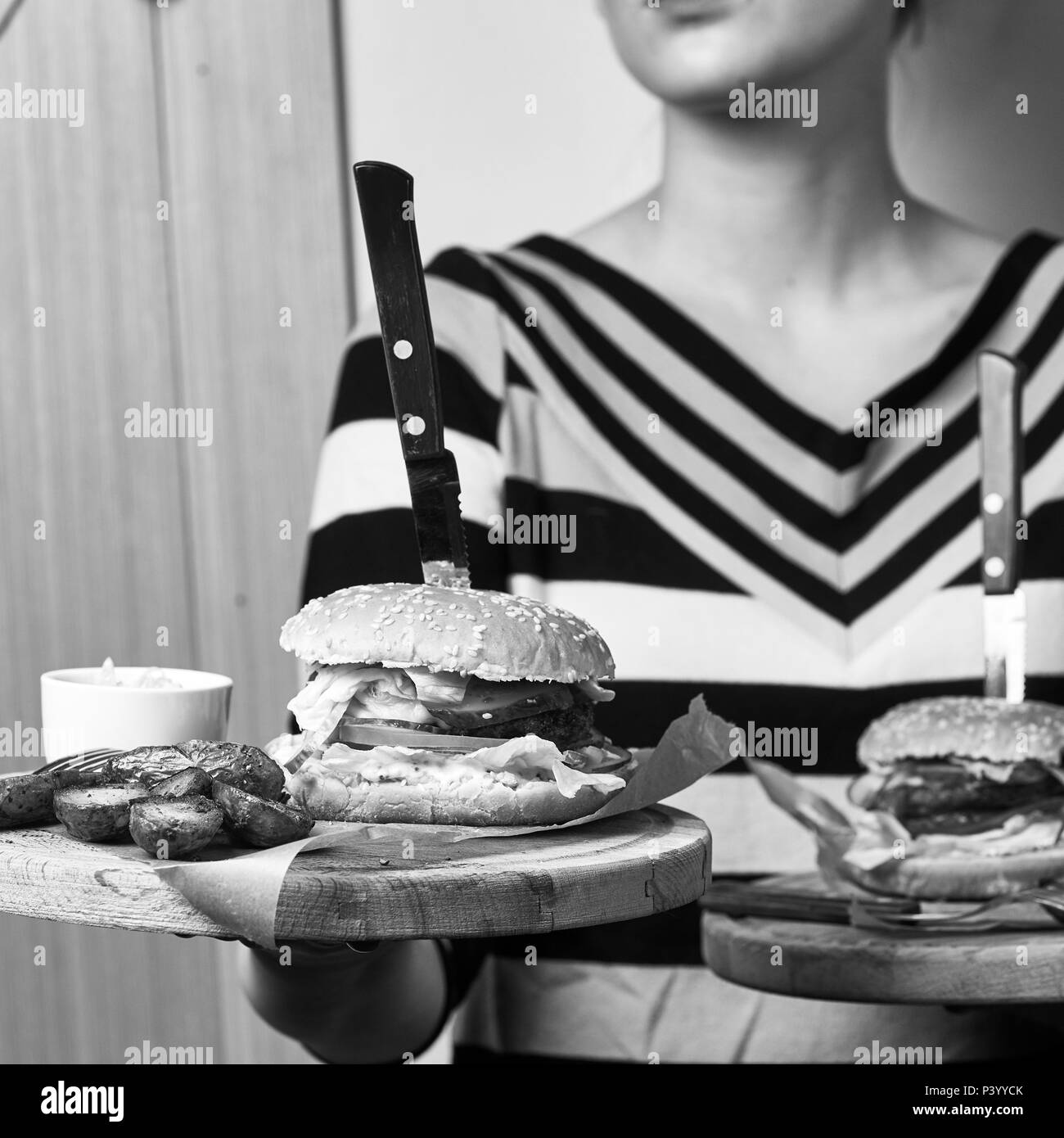 Frau mit Paar runden hölzernen Fächer mit Burger Stockfoto