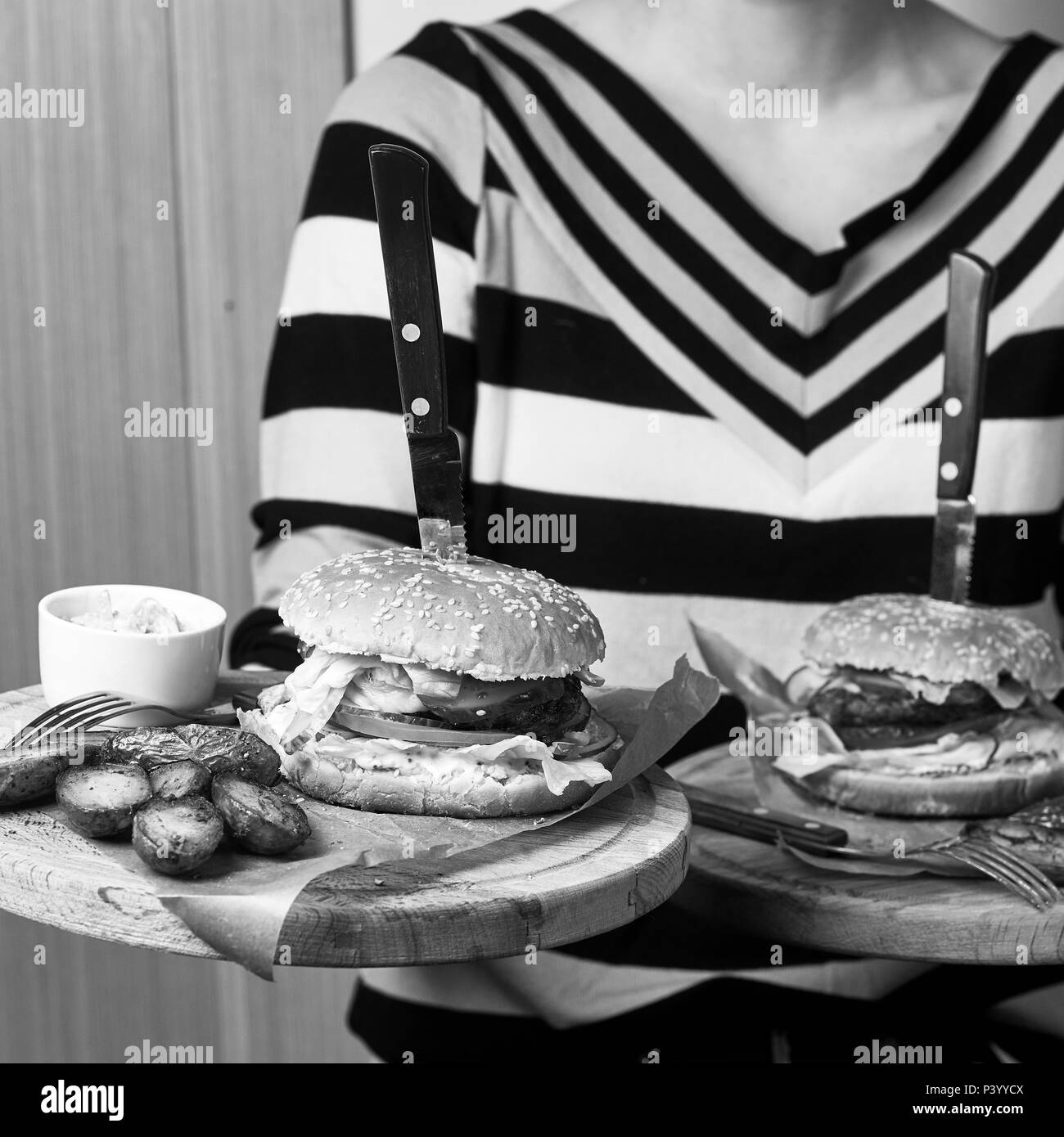 Frau mit Paar runden hölzernen Fächer mit Burger Stockfoto