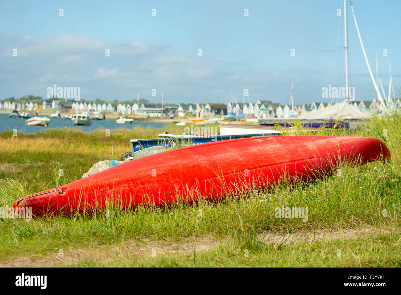 Rote Rumpf eines umgedrehten Kanu- und holzhütten am Mudeford Spit, Hengistbury Head, Christchurch, Dorset, Großbritannien Stockfoto