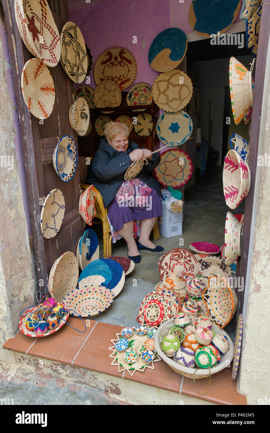 Castelsardo, Italien, 11. April 2018: Frau, die Produkte der Reed im Shop in Sardinien wie Körbe, diese Produkte werden in Handarbeit von den Menschen af Sardinien Stockfoto