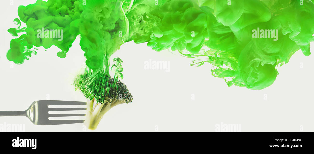Frischen Brokkoli auf eine Gabel mit einer Wolke der Auflösung Farbe. Künstlerische Ernährung Konzept. Wissenschaft der Nahrung Aktion Fotografie. Stockfoto