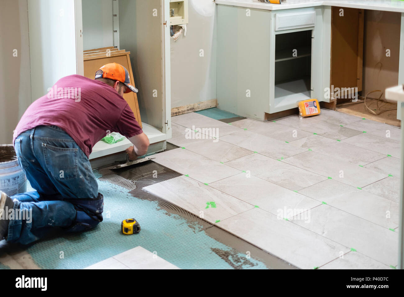 Ein 40 Jahre alter Kaukasischer Mann verlegen Fliesen in einem Hause Umbau in Wichita, Kansas, USA. Stockfoto