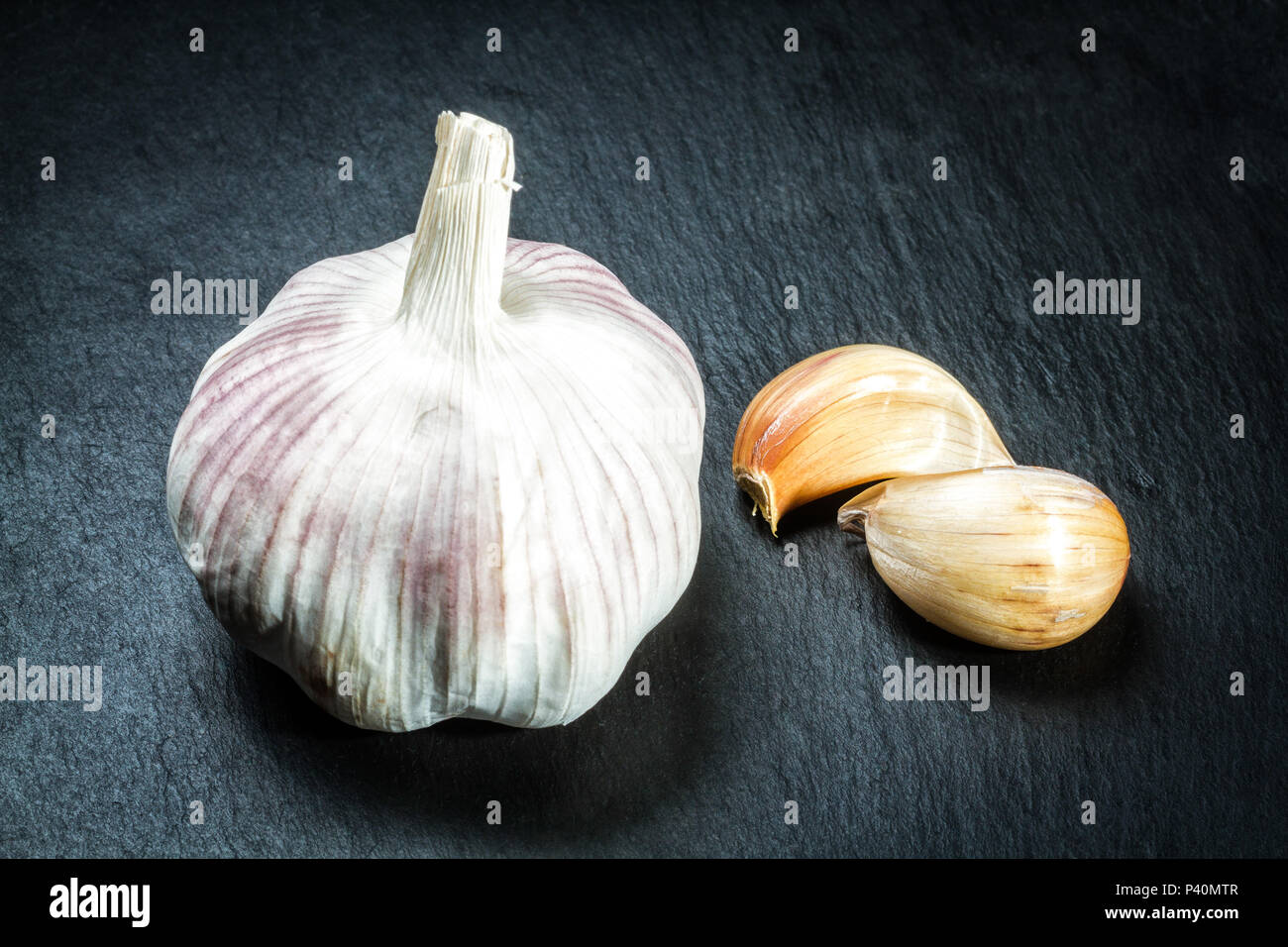 Cabeça de Alho e dentes de Alho (Allium sativum) sobre Tábua de ardósia. Florianópolis, Santa Catarina, Brasilien. Stockfoto