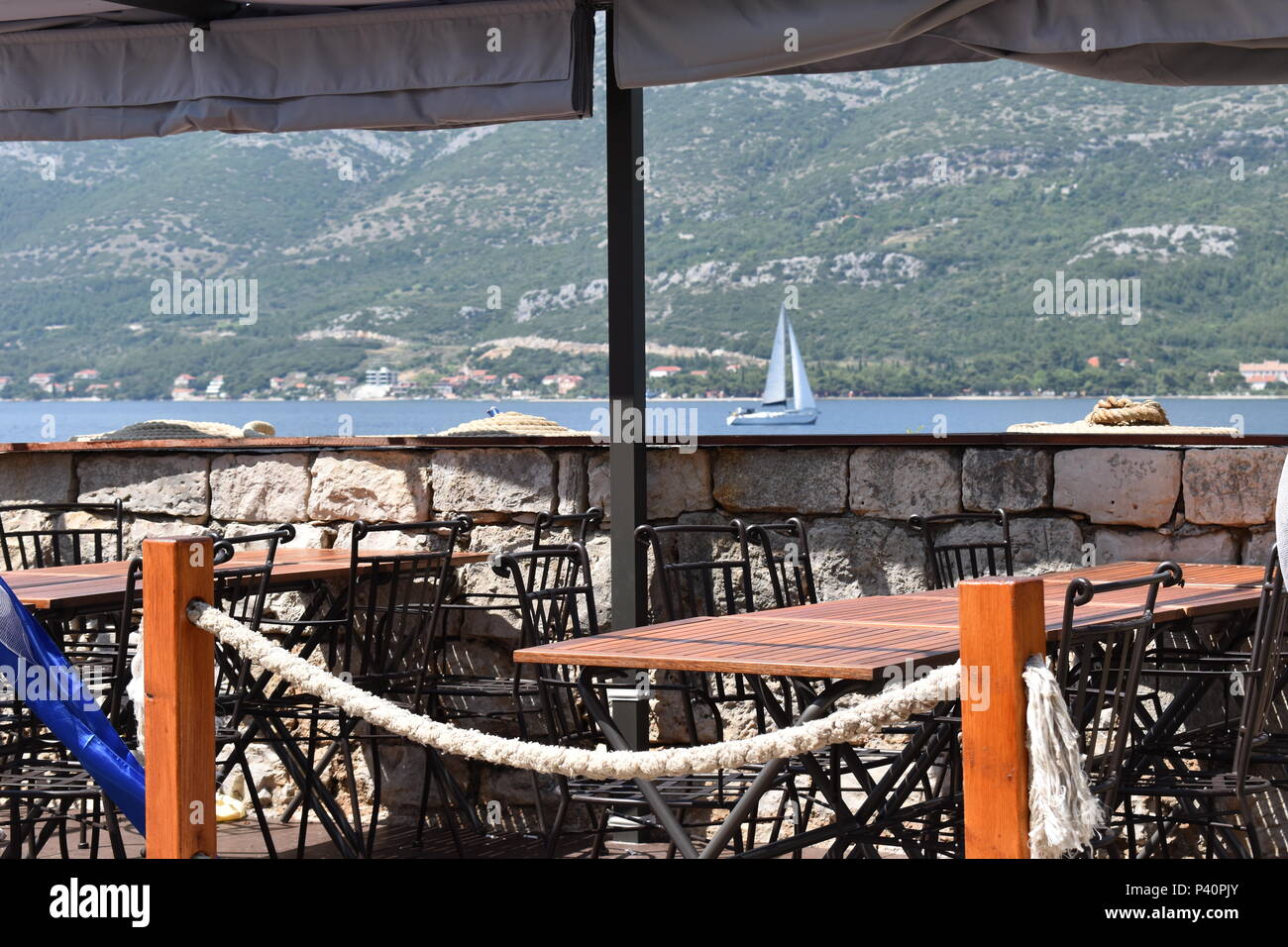 Meer anzeigen Restaurant auf die Stadt Korcula Promenade und ein Katamaran Hintergrund, Insel Korcula, Kroatien, Juni, 2018 Stockfoto