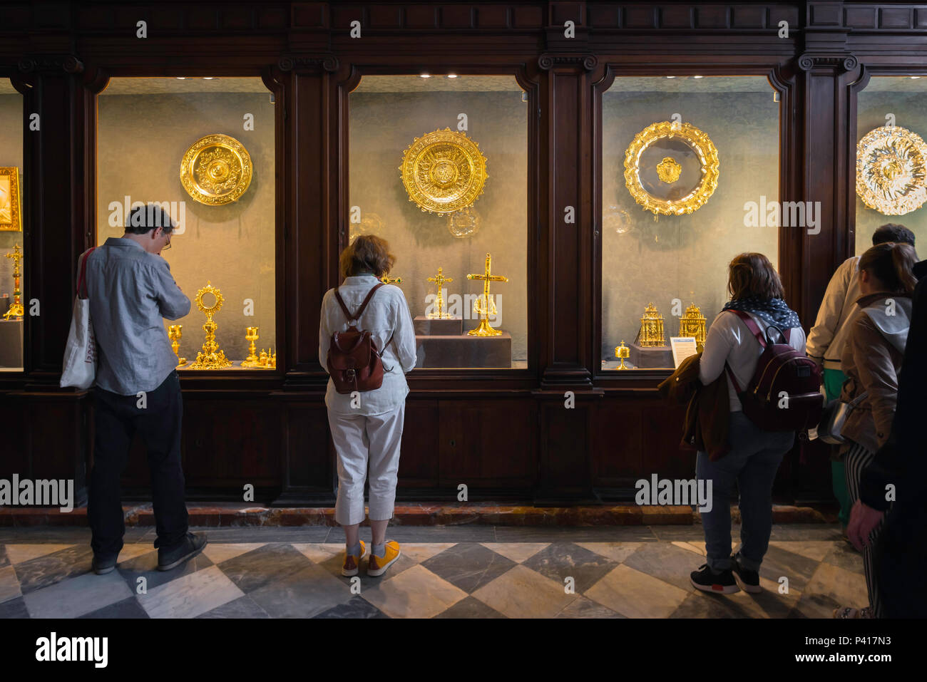 Die Kathedrale von Sevilla Treasury, Besucher zu der Schatzkammer in Sevilla Catedral Anzeigen einer Reihe von Gold religiösen Ornamenten, Sevilla, Andalusien, Spanien. Stockfoto
