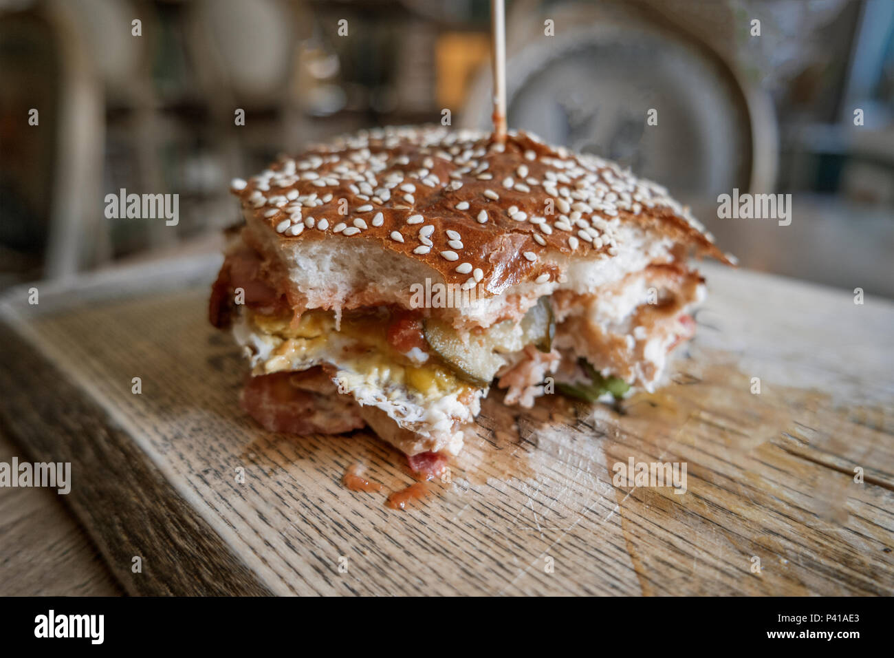 Bited Burger. Amerikanische Snack mit großen Hamburger auf Holzplatte. Stockfoto