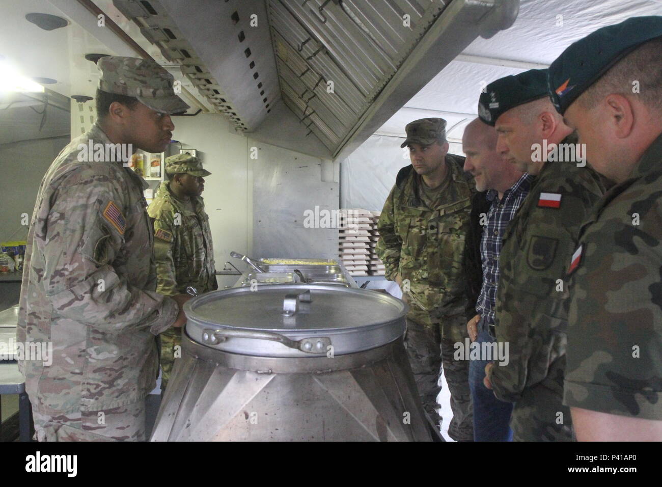 Spc. Kenneth Davis, einem kulinarischen Spezialist mit 3. Brigade Support Bataillons, 1st Armored Brigade Combat Team, 3rd Infantry Division zeigt die Polnischen 16 Garnison Support Team wie eine containerisierte Küche in Drawsko Pomorskie, Polen zu bedienen Juni 1 während einer taktischen Bereich Fütterung Demonstration. Stockfoto
