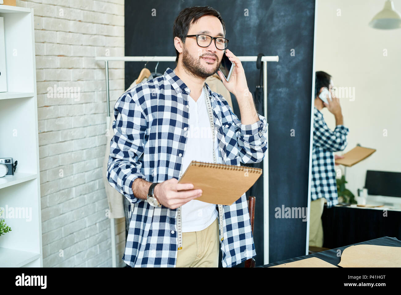Mann im Atelier im Gespräch mit Kunden am Telefon Stockfoto