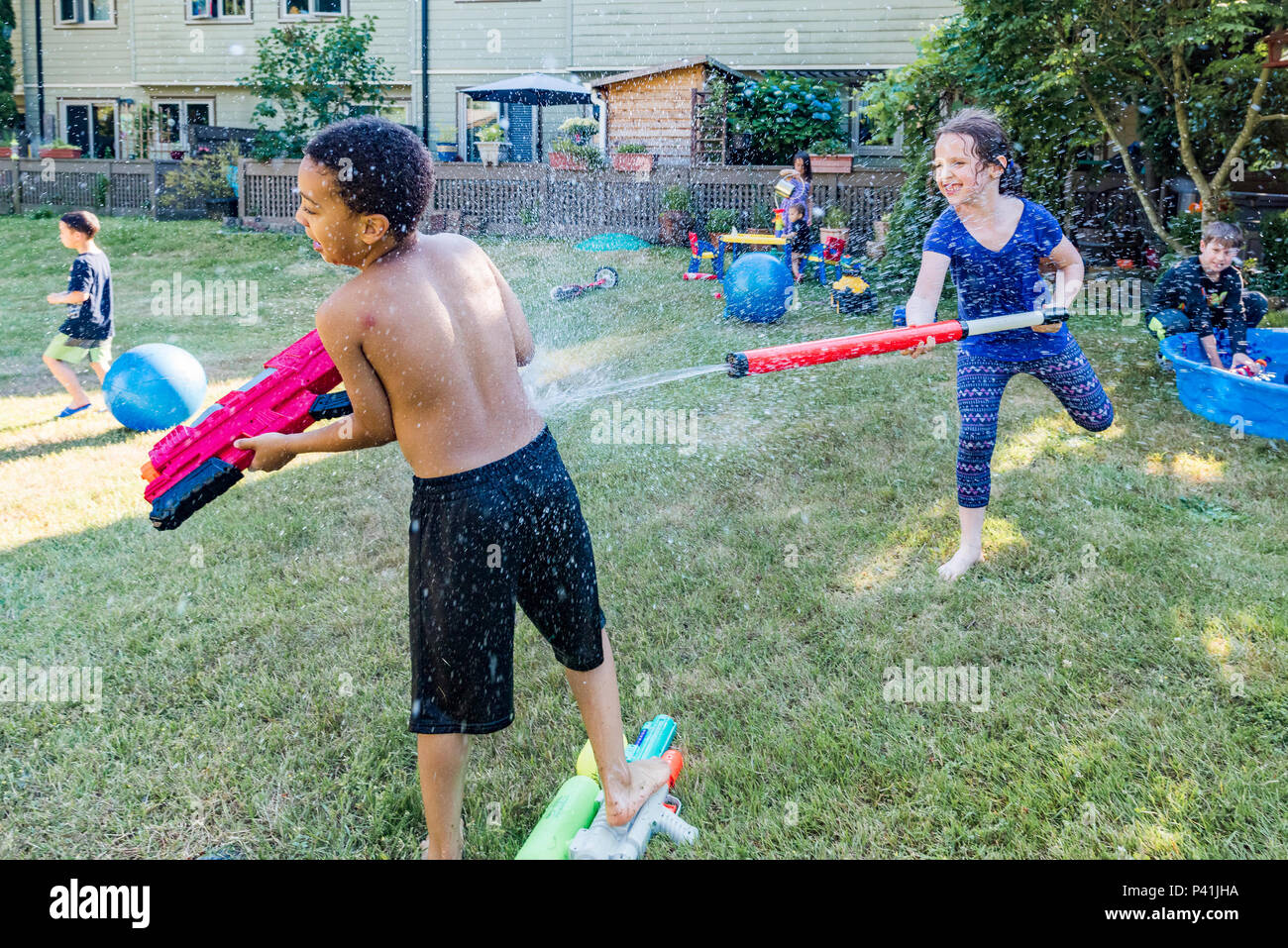 Cool bleiben, Sommer Spaß. Kinder haben freundlich Hinterhof Wasser kämpfen. Stockfoto