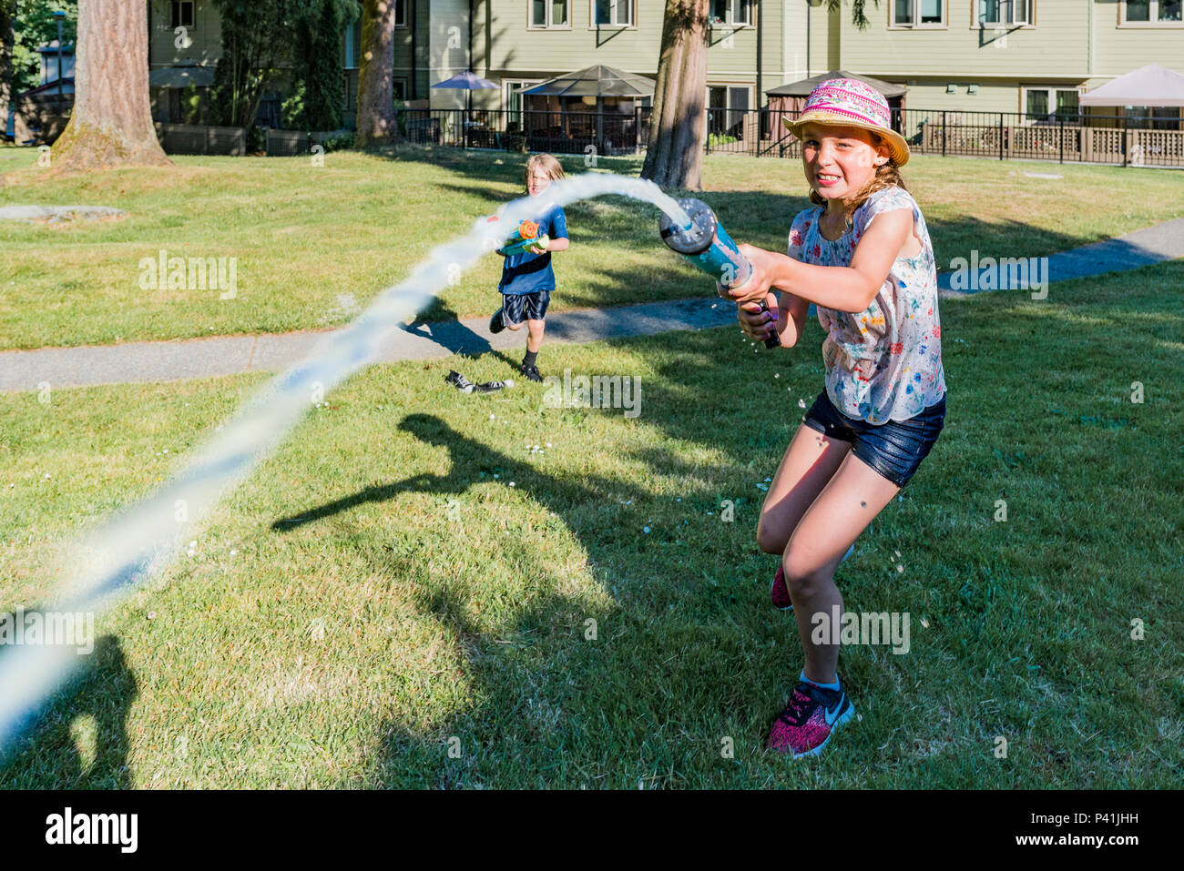 Cool bleiben, Sommer Spaß. Kinder haben freundlich Hinterhof Wasser kämpfen. Stockfoto