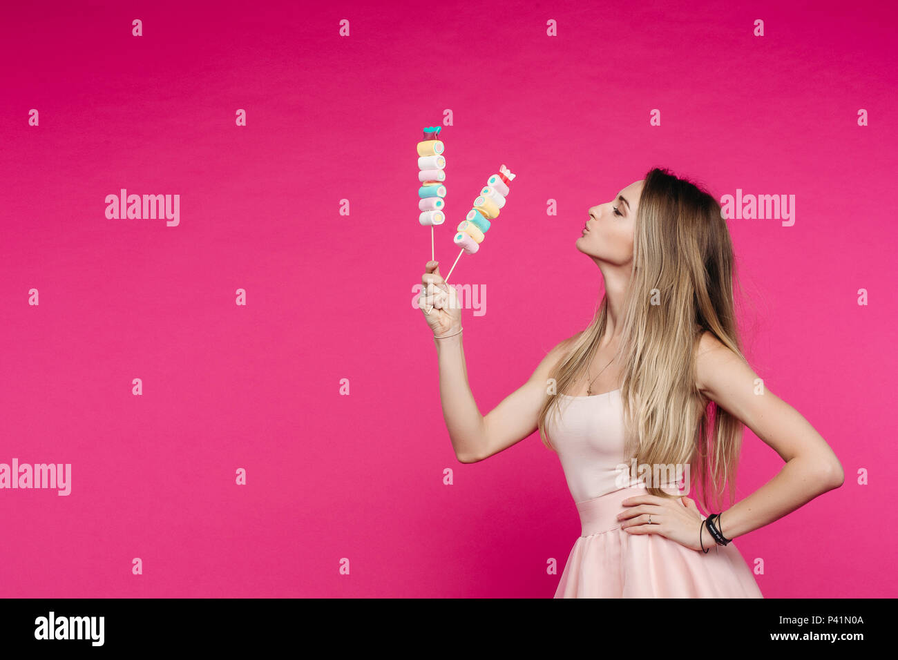 Funny Girl wie Puppe mit Marshmallow candy auf Stick. Stockfoto