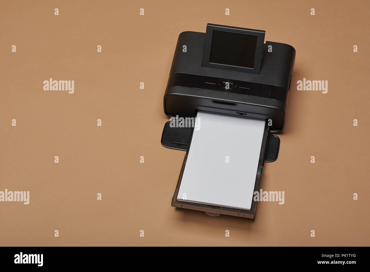 Kleiner, kompakter Drucker mit Papier auf gelbem Hintergrund Stockfoto