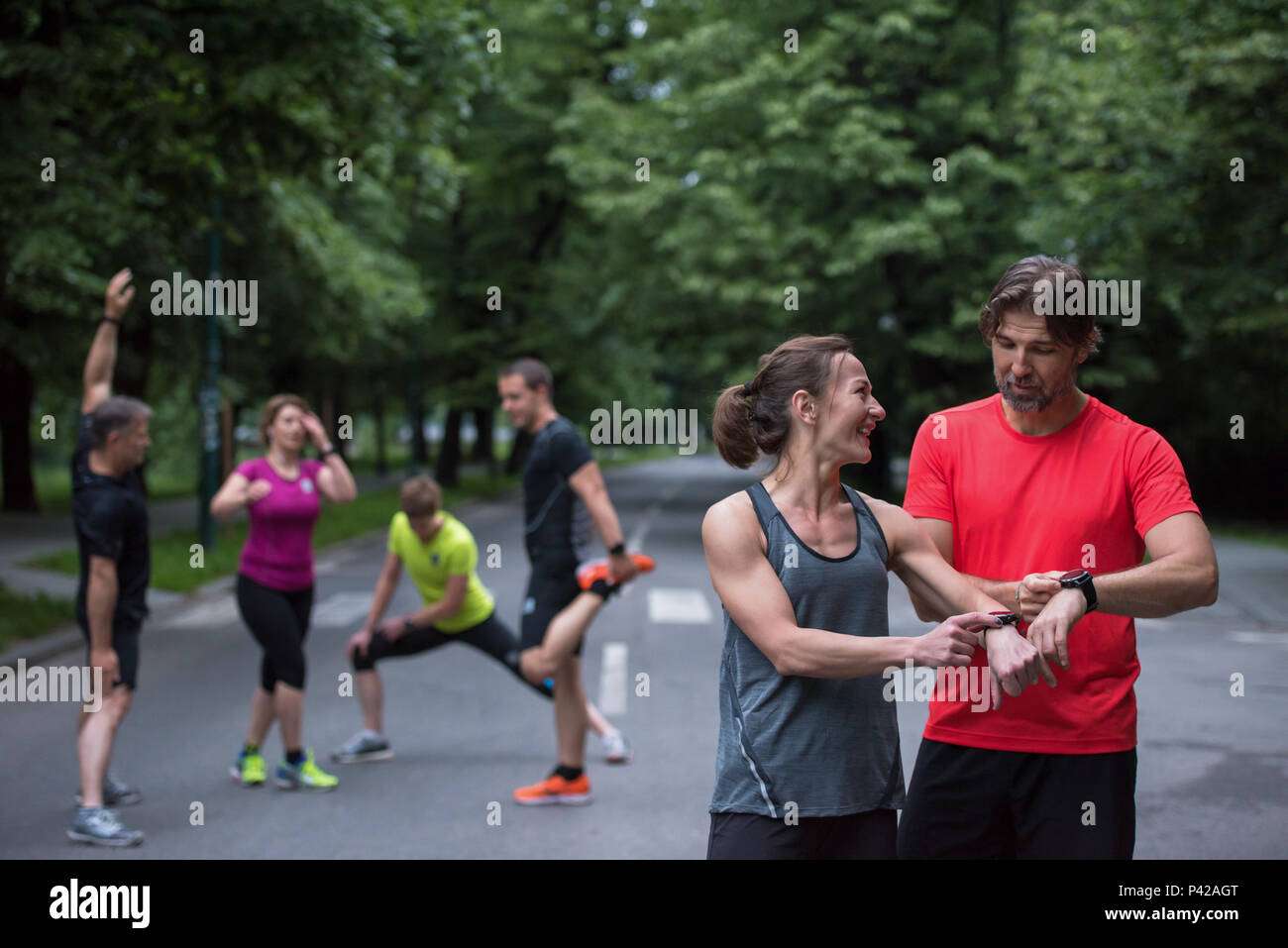 Junge sportliche Paar mit smart Uhren beginnen, ihre Timer vor dem Joggen Stockfoto