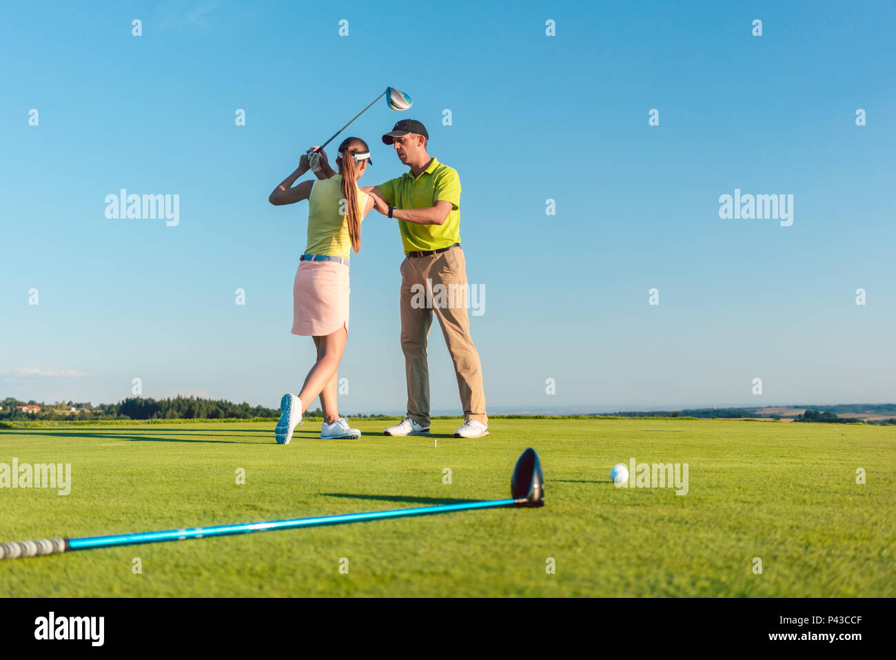 Golf Instructor Unterrichten einer jungen Frau, die Verein zu schwingen Stockfoto