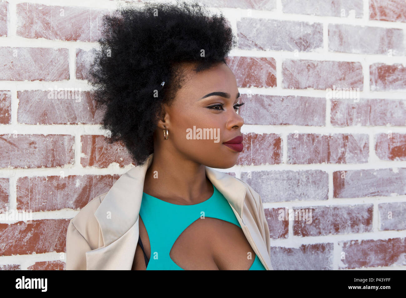 Eine afrikanische Frau Modell stellt in einem Ausschneiden Kleid gegen eine weiße Wand gewaschen Stockfoto