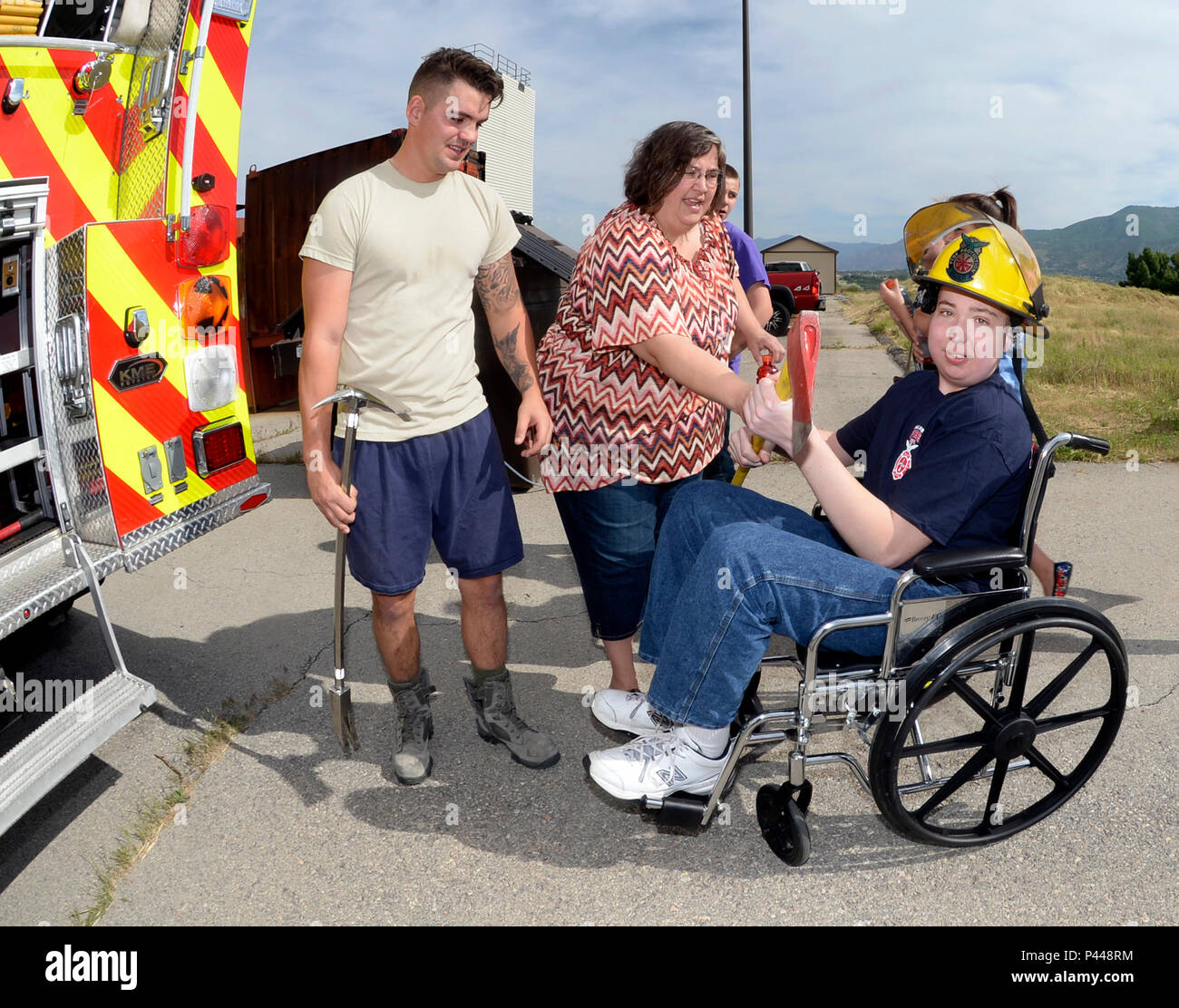 Staff Sgt. Anthony Runco, ein reservist in der 419Th Bauingenieur Squadron, spricht von Brandbekämpfungsausrüstung mit Joshua Jones und seine Familie 9. Juni auf der Hill Air Force Base in Utah. Jones, die dauerhaft eine lebensbedrohende Krankheit, wurde ein Feuerwehrmann für einen Tag. Während hier, und er ist Familie bereiste eine Feuerwehr, Ritt in einem Löschfahrzeug und in der Brandbekämpfung Übungen teilgenommen. (U.S. Air Force Foto von Todd Cromar) Stockfoto