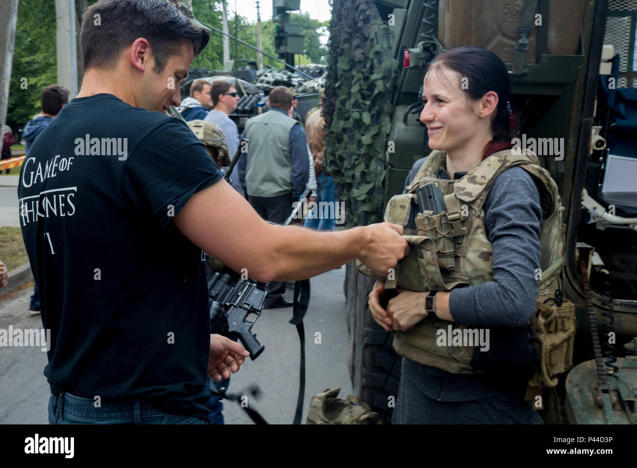 Eine lokale Frau versucht auf Schutzkleidung während eine statische Darstellung mit der 4. Staffel, 2 Cavalry Regiment in einem Park in Kupiskis, Litauen vom 12. Juni 2016, während der Dragoner reiten II, eine 2.200 Kilometer lange Konvoi nach Estland für Übung Sabre Streik 16. Übung Sabre Streik 16 ist ein US-Army Europe - LED-kooperative Ausbildung Übung entwickelt gemeinsame Interoperabilität multinationaler Blindbewerbungen zu unterstützen, zu verbessern. (U.S. Armee Foto: Staff Sgt. Ricardo HernandezArocho/Freigegeben) Stockfoto