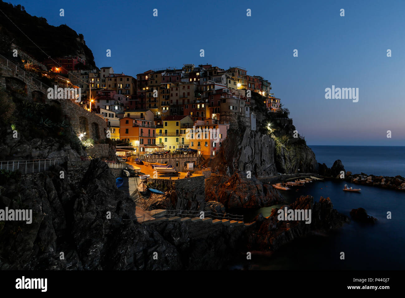 Auf Manarola Hafen bei Nacht mit glühenden Lichter und ruhiges Meer Stockfoto