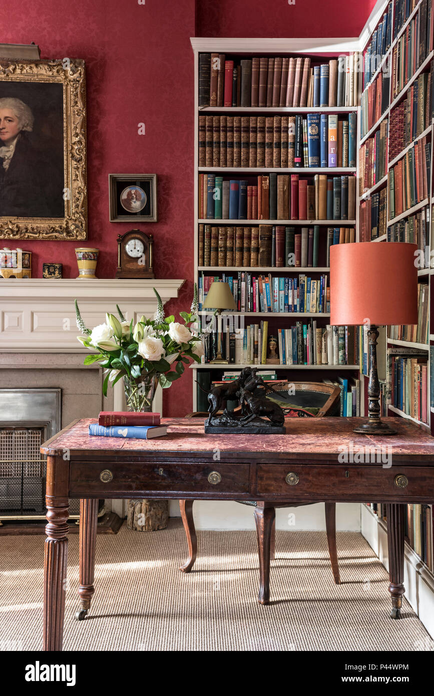 Antiker Schreibtisch und Bücherregalen weisse Rosen an der Viktorianischen Schreibtisch mit Bücherregalen Stockfoto