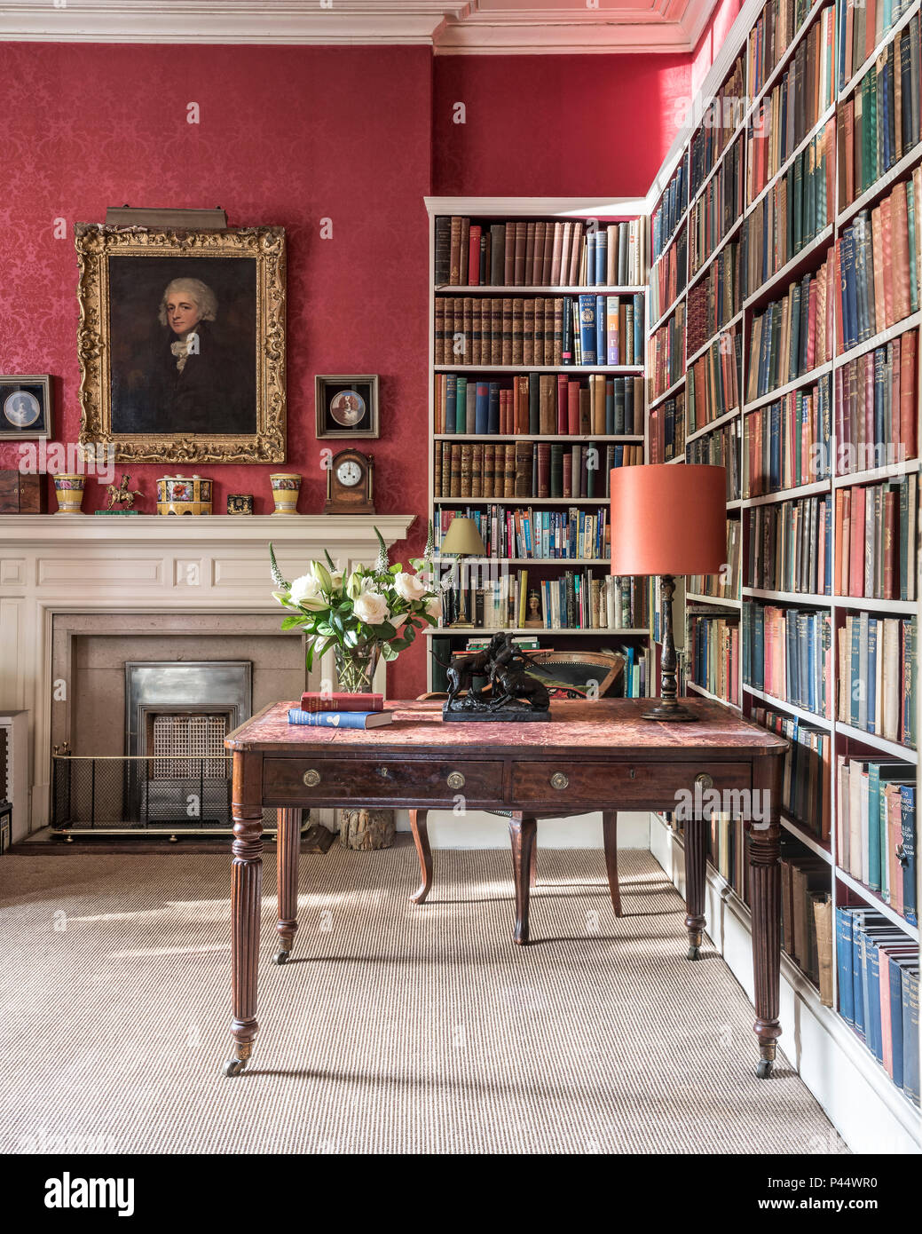 Antiker Schreibtisch und Bücherregalen weisse Rosen an der Viktorianischen Schreibtisch mit Bücherregalen Stockfoto