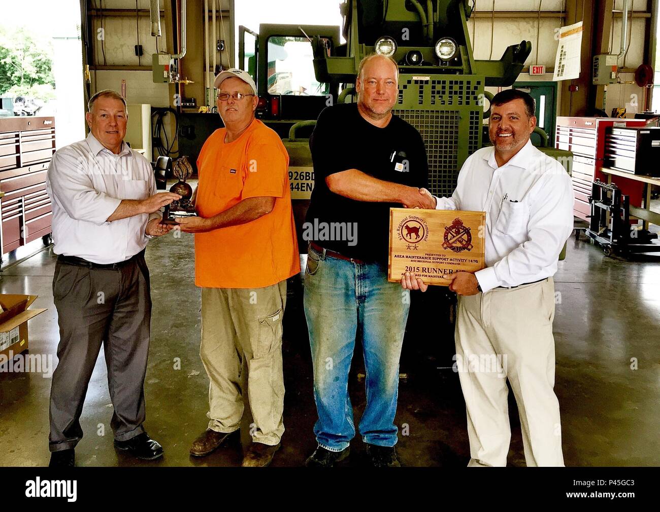 81. Regionale Unterstützung Befehl Direktor der Logistik Ardis Ferguson präsentiert John White mit einer Trophäe, während sein Stellvertreter, Gregg Charvoz präsentiert George Boy mit einer Plakette in Anerkennung der Leistungen der Shop. Bereich Wartung Support Activity 147 G gewann die USARC-Armee Award für Exzellenz und konkurriert in der Abteilung der Armee. Stockfoto