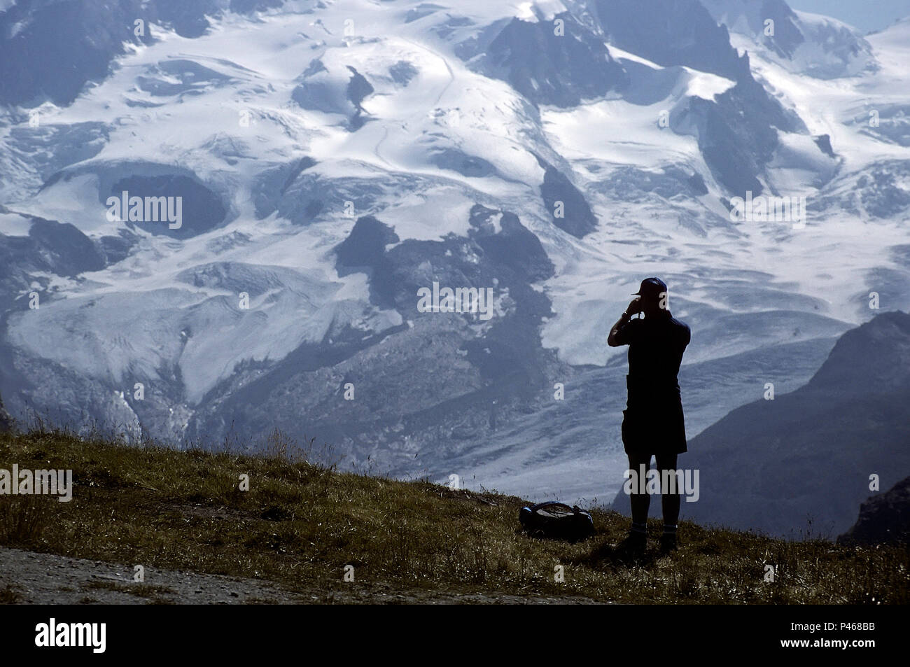 Ein Bergsteiger Studium eine prospektive Route auf einem Berg mit Fernglas, Schweizer Alpen Stockfoto
