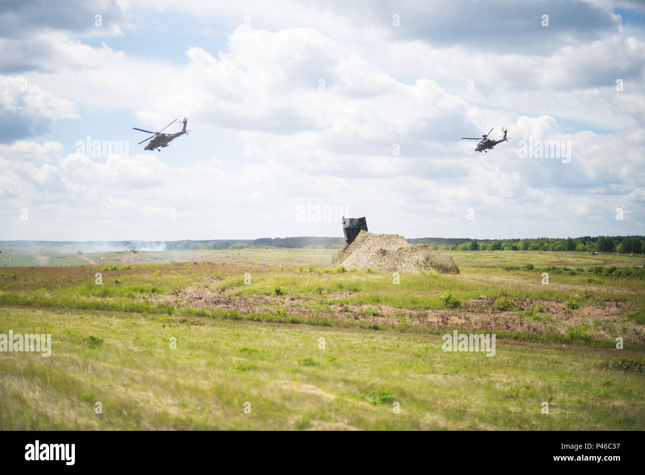 Zwei AH-64 Apache Hubschrauber ziehen die Sicherheit für einen Live-fire Rakete Übung von zwei MI-24 während der berühmten Besucher Tag dynamische Anzeige während des Betriebs Anakonda 2016 Hinds. Stockfoto