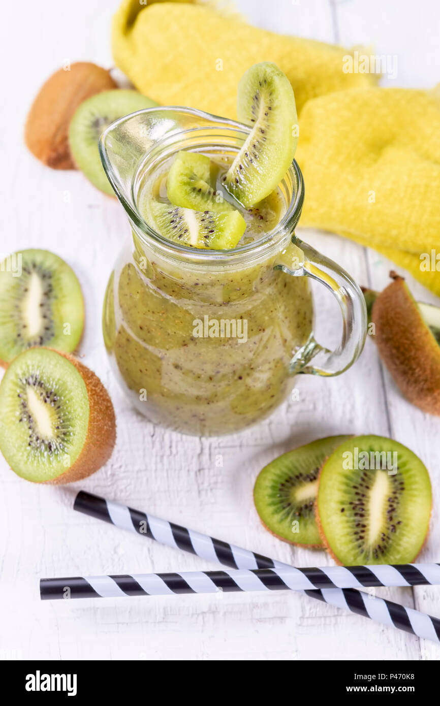 Gesunde, frische kiwi Smoothie in Glas auf einer hölzernen Hintergrund. Fokus auf kiwi Schicht in eine Karaffe. Stockfoto