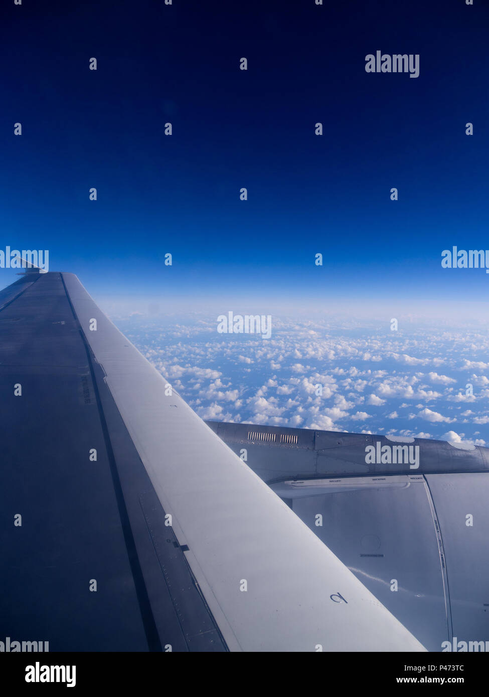 Blick über den Wolken aus dem Flugzeugfenster Stockfoto