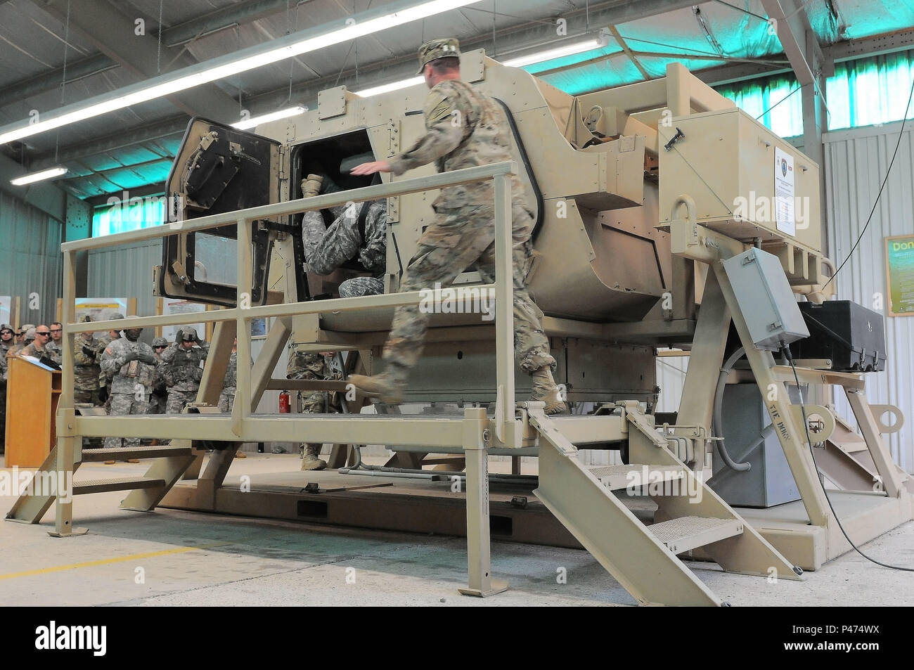 Ein Ausbilder hetzt, um Soldaten in das Verlassen eines simulierten rollte über Fahrzeug beim HMMWV Egress Hilfe Training (Wärme) an den Beobachter Trainer Trainer Akademie, in Betrieb schnelle Reaktion bei JMRC, Hohenfels Training Bereich im südöstlichen Deutschland zu unterstützen, 10. Juni 2016. Hitze lehrt Soldaten, wie sie zu reagieren haben und im Falle eines Fahrzeugüberschlag Fall überleben. Übung schnelle Reaktion ist eines der führenden militärischen Krisenreaktion Schulungen für multi-nationale zerstreuten Kräfte in der Welt. Die Übung ist so konzipiert, dass die Bereitschaft der Bekämpfung der Kern der U.S. Global Response Force zu verbessern - Stockfoto