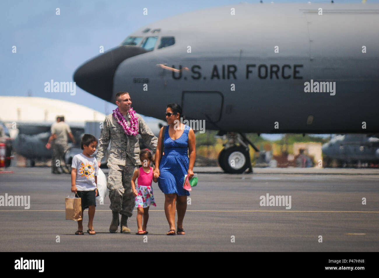 Einen Flieger von 203Rd Luftbetankung der Texas Air National Guard Squadron grüßt seine Familie nach seiner Rückkehr von der Bereitstellung Jun.16, 2016, Joint Base Pearl Harbor-Hickam. Mehr als 50 Mitglieder, drei KC-135 Stratotankers, Flug- und Wartungspersonal und andere Supportmitarbeiter wurden für vier Monate als Teil einer Air Expeditionary Force Rotation eingesetzt. (U.S. Air National Guard Foto von Airman 1st Class Robert Cabuco/freigegeben) Stockfoto