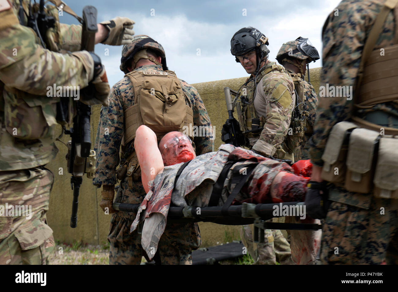 Us-Marines auf der Special-Purpose Marine Air-Ground Task Force Crisis Response Afrika Gerät zugeordnet ist, einen Unfall opfer auf einer Bahre bei einer gemeinsamen Übung in Stanford, England, 14. Juni 2016. Britische amputees freiwillig als verletzte Service Mitglieder Realismus zum Training Szenarien hinzuzufügen. (U.S. Air Force Foto/Airman 1st Class Abby L. Finkel) Stockfoto