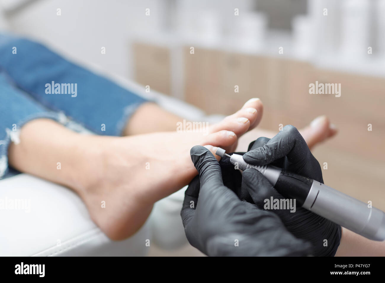 In der Nähe von Doktor in Handschuhe Verfahren für Fuß mit speziellen elektrischen Ausrüstung fo-Client. Sorge um Fuß und Nägel im Schönheitssalon. Podiatr Stockfoto
