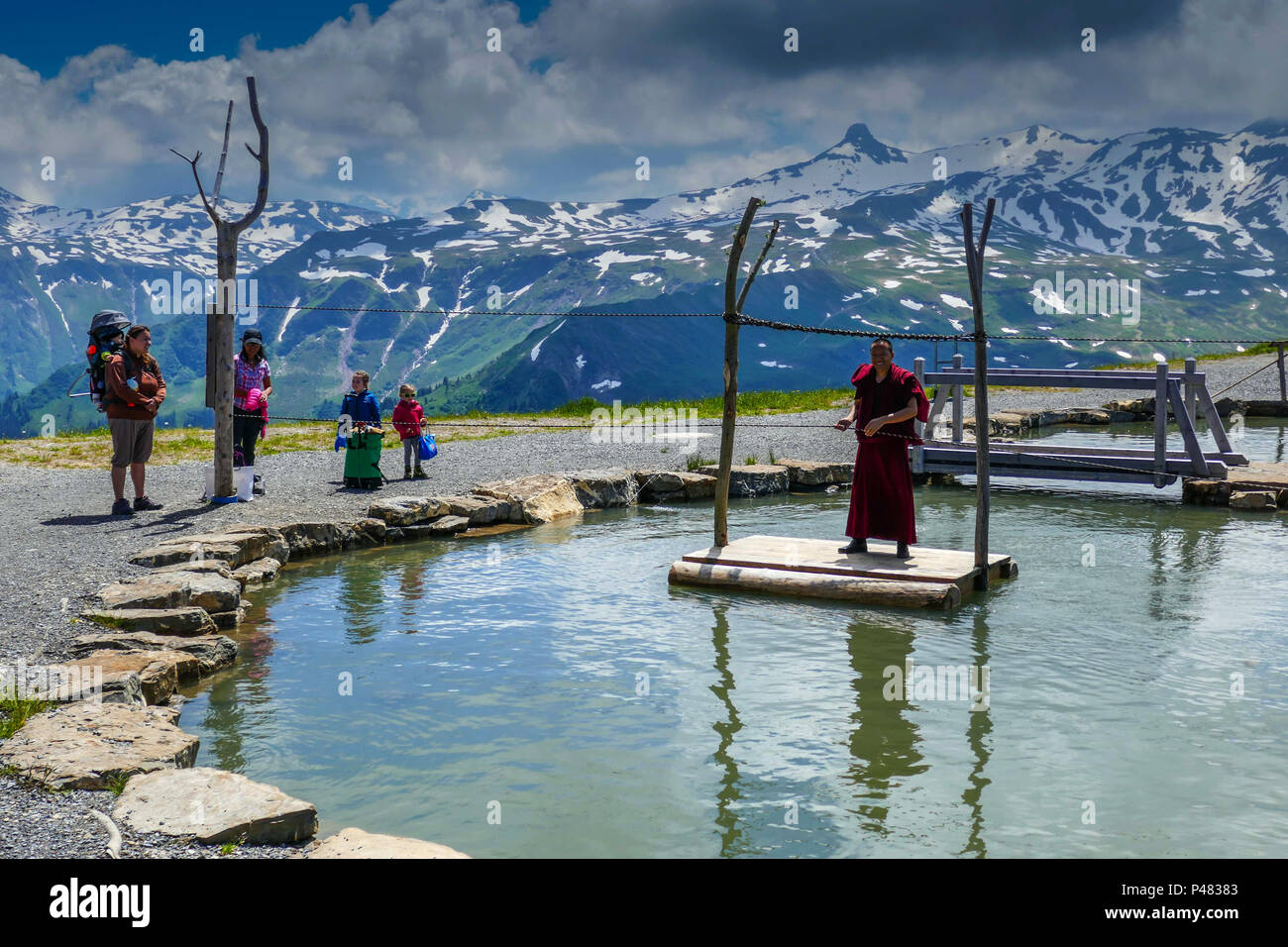 Tibetische buddhistische Mönche in roten Roben, die in der Schweiz spielen  auf schwimmende Plattform Stockfotografie - Alamy