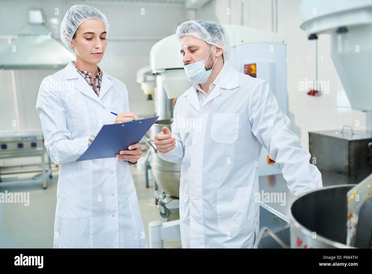 Professionelle Konditoren diskutieren in der Factory Stockfoto