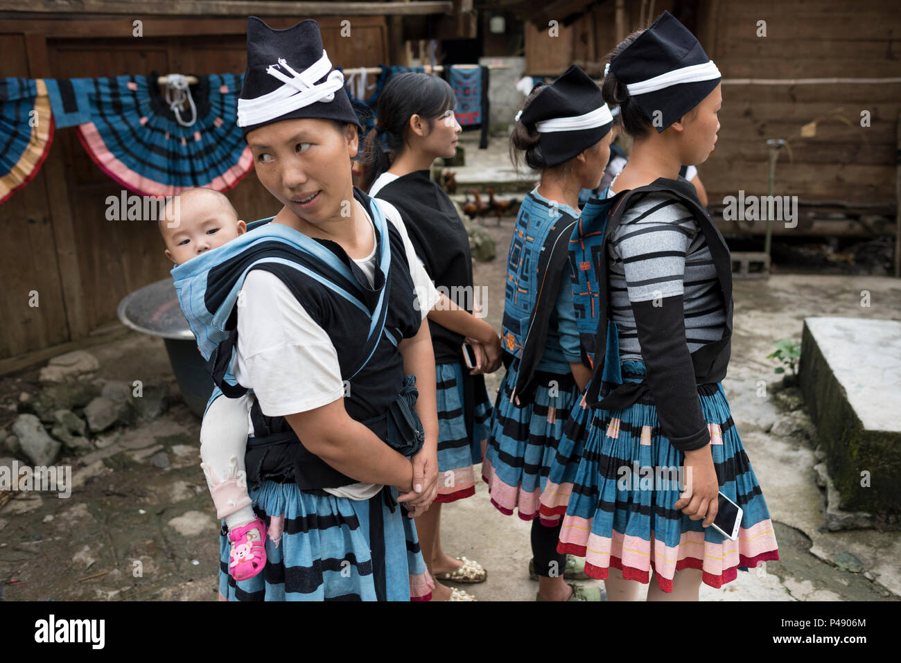 Mütter mit Babys in Schulter Träger beobachten, Leistung, Yao ethnische Minderheit Dorf Yao Shan, Libo, Provinz Quizhou, China Stockfoto
