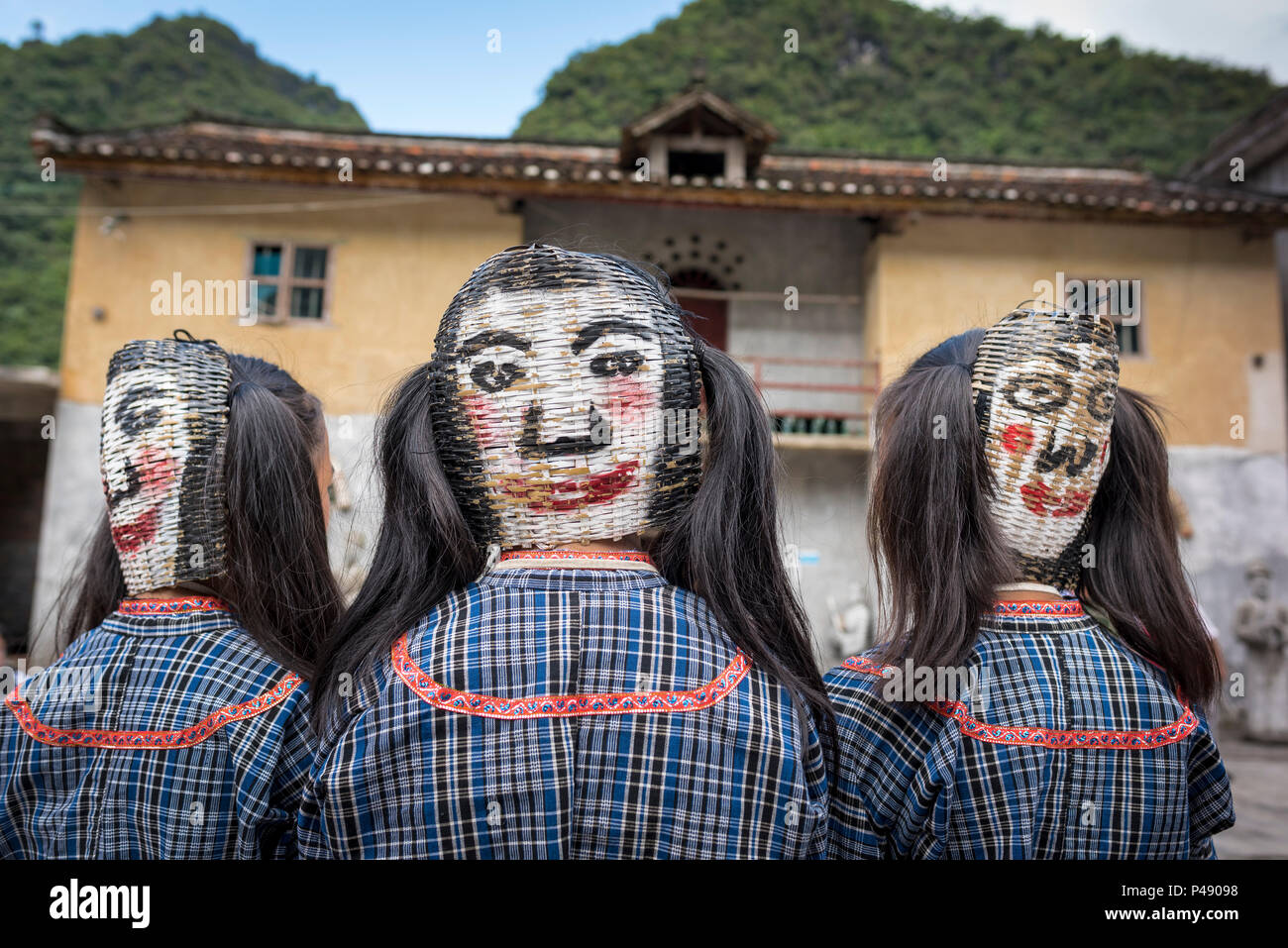 Kostümierte jugendlich Mädchen tragen Gesichtsmasken gemalt, Buyi ethnische Minderheit Dorf, Li Feng, Libo, Provinz Guizhou, China. Stockfoto