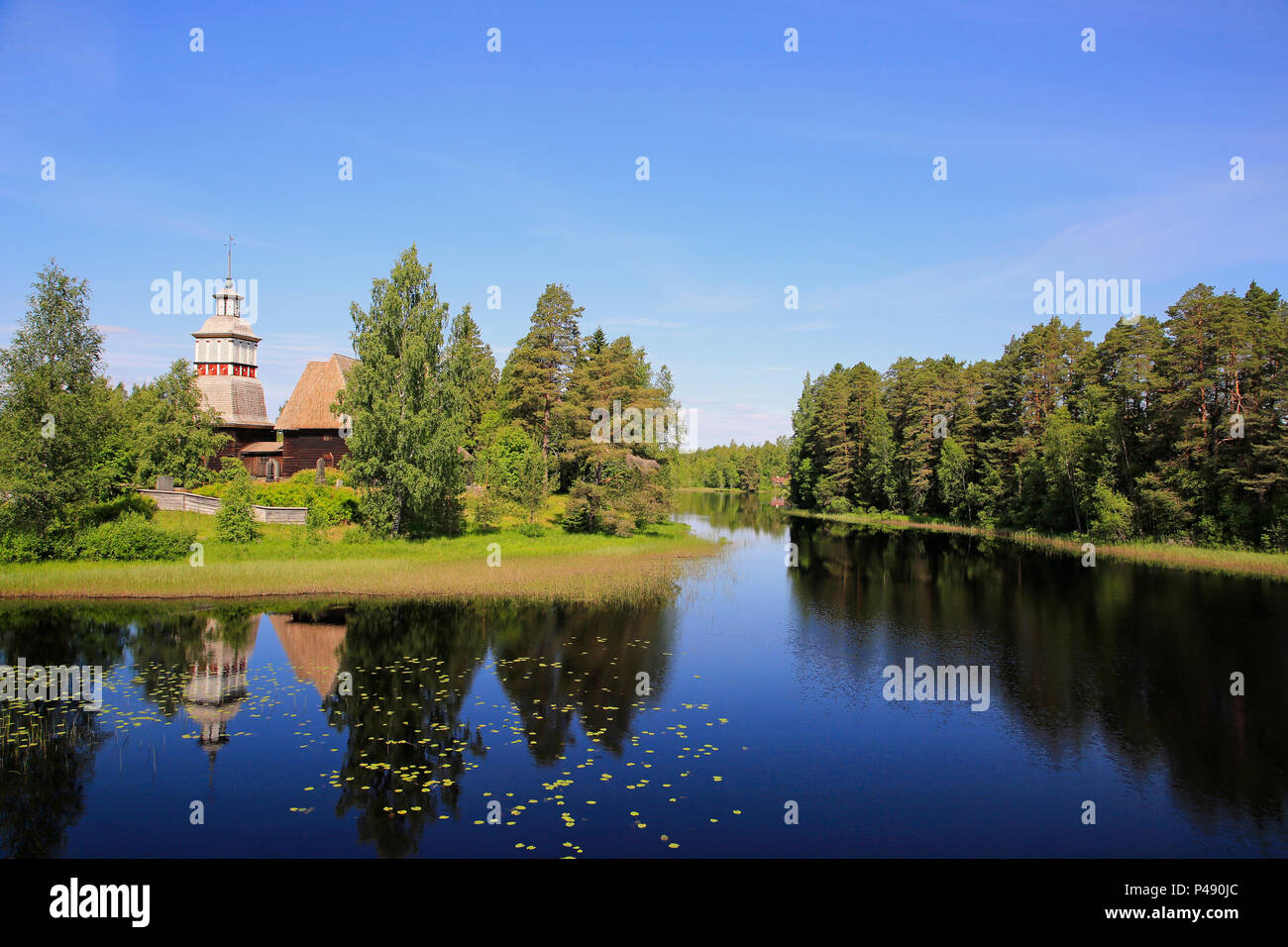 Finnische blauen See und Himmel Landschaft mit UNESCO-Weltkulturerbe, alte hölzerne Kirche von Petajavesi, Finnland im Sommer. Die Kirche wurde 1763-65 erbaut. Stockfoto